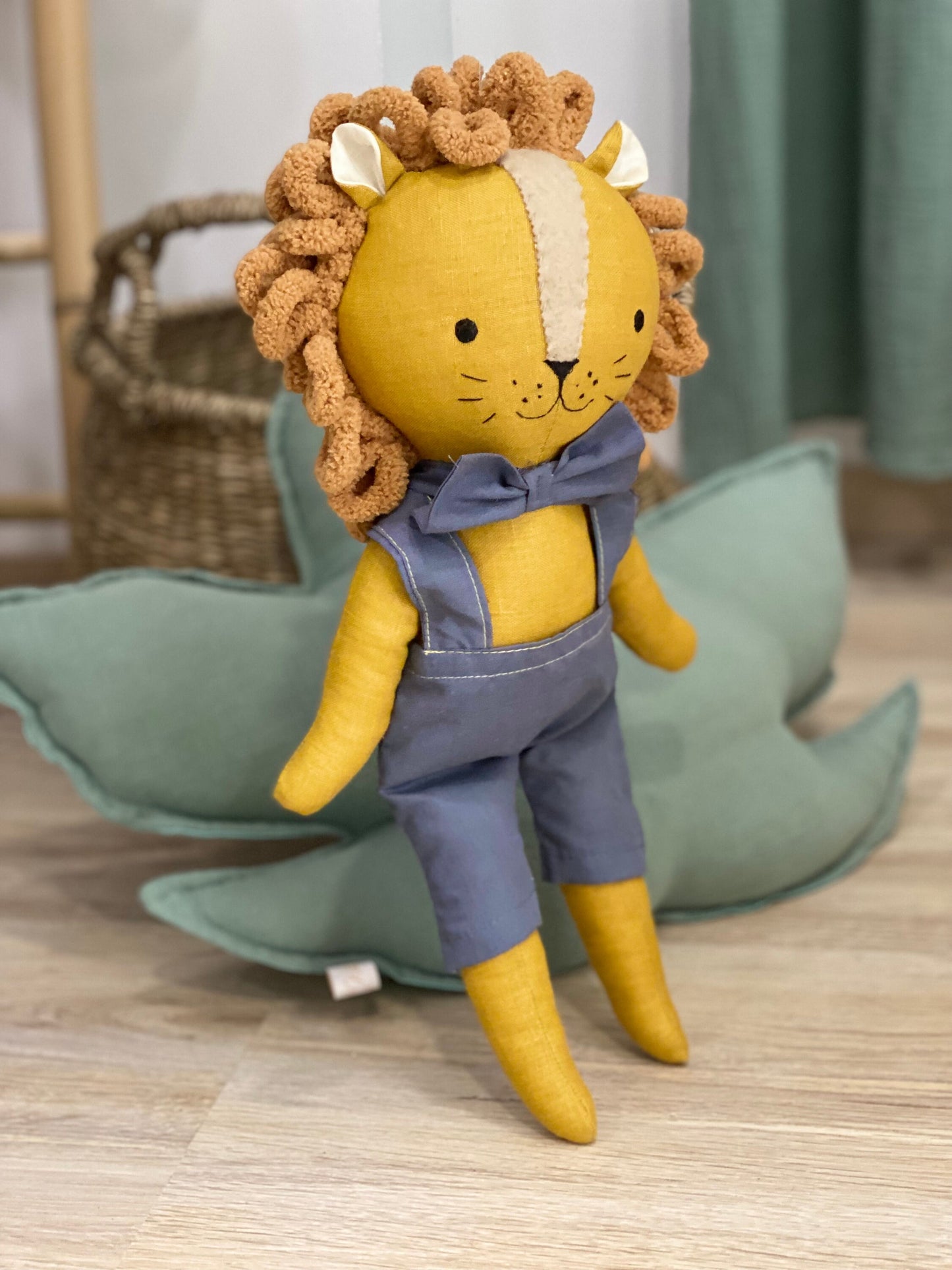 Handmade safari lion fabric doll sitting on wooden floor in neutral kids room